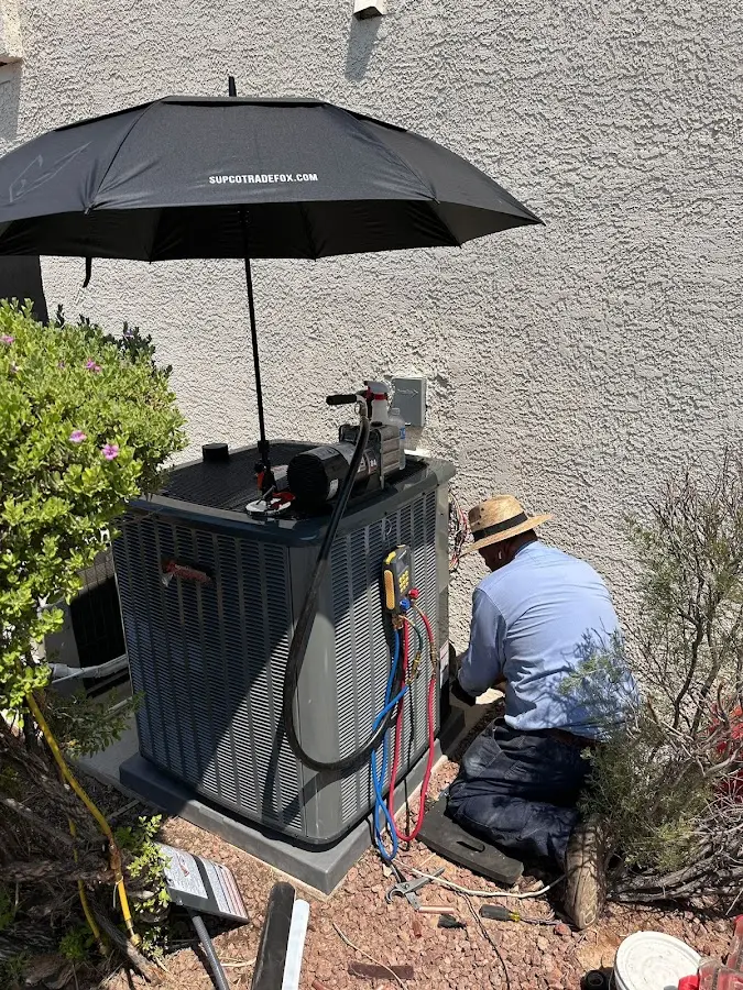 HVAC technician performing outdoor AC maintenance in Buena Vista
