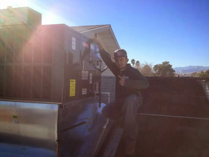 HVAC technician performing Heat Pump Repair on a rooftop unit in Buena Vista